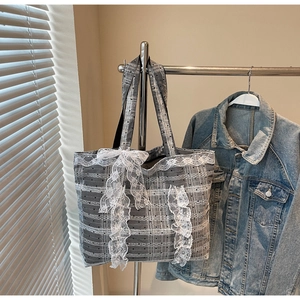 Détail du sac cabas à carreaux gris avec grand nœud en dentelle blanche et bords volantés
