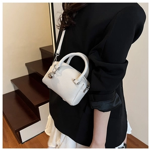 Détail du mini sac Boston blanc à motif litchi avec ferrures argentées et zip à bille