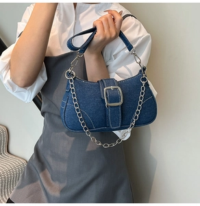 Detail of vintage denim crossbody bag with silver chain and contrast stitching