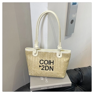 Detail showing woven texture and white synthetic leather shoulder straps of the tote bag
