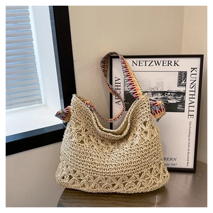 Detail of hollow star crochet pattern on straw tote bag with ethnic style woven strap