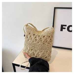 Close-up of beige woven bucket bag with floral hollow-out texture and wooden buckle detail