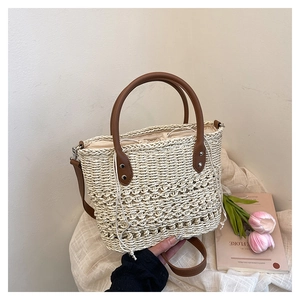 Detail of hand-woven straw bucket bag with leather handles and drawstring lining closure