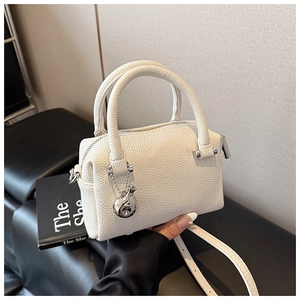Détail du mini sac Boston en cuir litchi blanc avec breloque cochon argentée et poignée