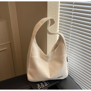 Detail of white canvas hobo bag showing MERREY logo label and external pocket