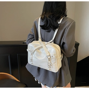 Detailed back view of a white patent leather JK style shoulder bag with embroidery