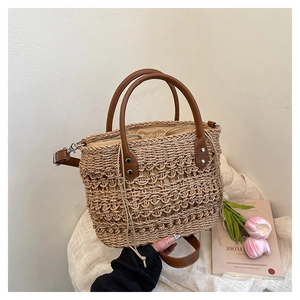 Detail of straw bucket bag with brown leather handle and drawstring closure
