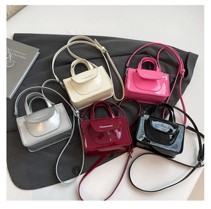 Close-up of stylish mini patent leather bags in cream, magenta, silver, and black