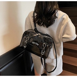 Detail of black patent leather backpack with silver metal hardware on back view