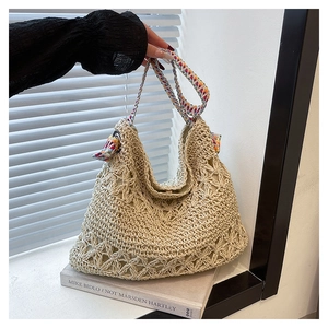 Detail of hand-woven straw tote bag with colorful bohemian strap and magnetic closure