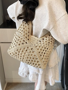 Large beige hollow straw shoulder tote bag for summer beach holidays on female model