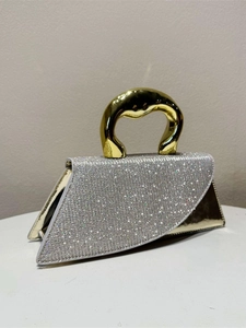 Silver rhinestone evening bag with elegant asymmetric flap and sculptural gold metal handle