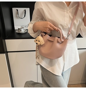 Sac seau rose en cuir grainé avec poignée nouée et breloque chien en peluche