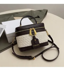 Detail of a luxury box bag with dark brown leather and beige woven texture
