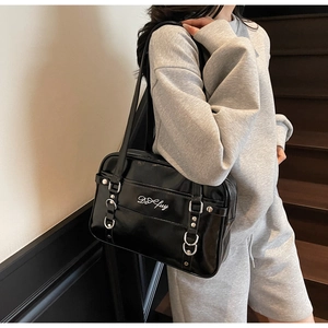 Detail of glossy black PU leather JK uniform bag with embroidery and silver D-rings