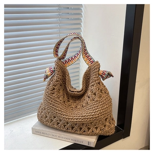 Close-up of woven straw tote bag featuring crochet patterns and colorful geometric straps