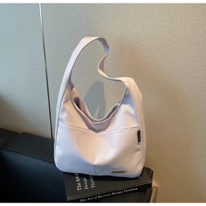 Detail of light purple soft nylon hobo shoulder bag placed on a black sofa setting