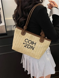 Chic woven straw tote bag with brown leather handles and black letter embroidery
