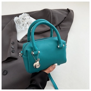Détail du sac Boston en cuir grainé bleu sarcelle avec finitions argentées chic