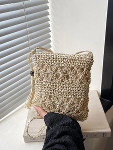 Beige crochet bucket bag with hollow flower patterns and stylish fringe tassels