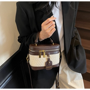 Close-up of retro PU bucket bag featuring woven texture and gold dual zippers