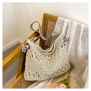 Detail of bohemian crochet tote with intricate flower pattern and colorful woven strap