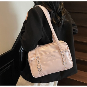 Pink JK style faux leather shoulder bag with floral embroidery on wooden stairs