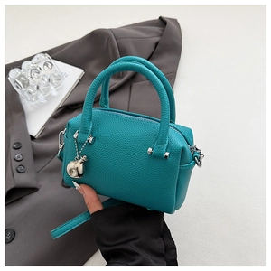 Détail du sac Boston vert menthe avec texture grainée et finitions métalliques argentées