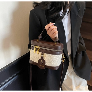 Detail of leather crossbody bag with woven texture and gold fashion tag accessory