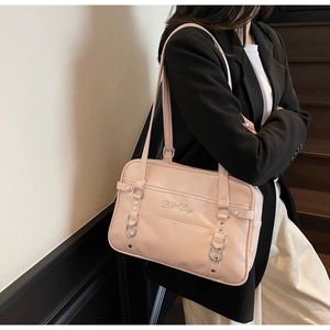 Detail of pink PU leather shoulder bag with silver studs and logo embroidery