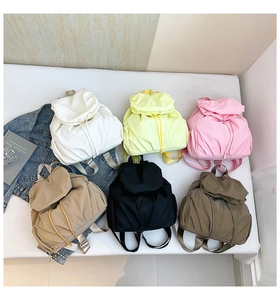 Flat lay of lightweight pleated nylon backpacks in six colors with drawstring closure