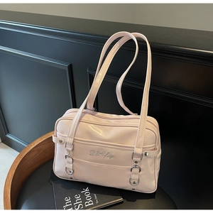 Close-up of pink shiny leather shoulder bag featuring silver D-fuy logo on black chair
