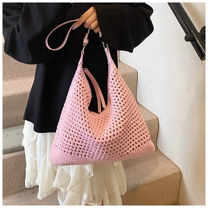 Detail of pink knitted hobo beach bag with mesh texture and adjustable leather strap