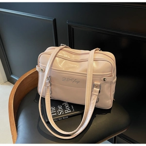 Detail view of light pink PU leather tote bag with embroidery on a vintage chair