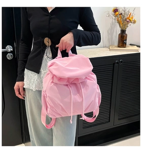 Detail of pink ruffled nylon backpack featuring drawstring closure and side pockets