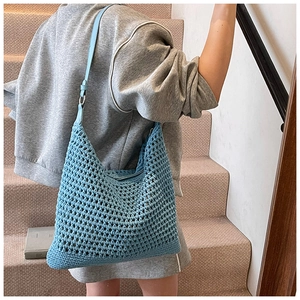 Macro shot of light blue hand-woven texture and leather strap on a beach shoulder bag