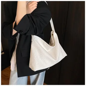 White woven faux leather hobo bag styled with a black blazer on a model