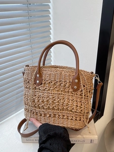 Large capacity straw woven bucket bag with brown faux leather handles and inner drawstring