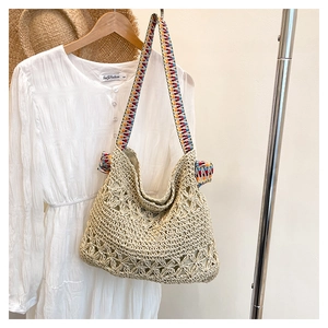 Detail of woven straw tote bag with colorful geometric jacquard shoulder strap for summer