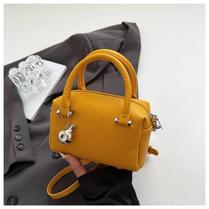 Détail du mini sac Boston en cuir jaune grainé avec fermeture éclair argentée