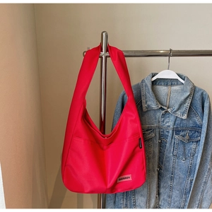 Detail of red nylon hobo bag showing the MEAREY logo patch and TANDAIEER brand label