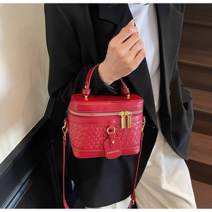 Detail of red PU leather bucket bag featuring a woven texture and metal zipper
