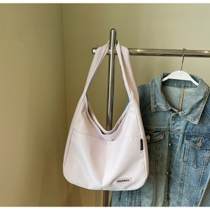 Detail of light purple nylon tote bag with MEAREY brand label and wide shoulder strap