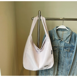 Detail of light purple nylon hobo bag featuring external pocket and textile brand label
