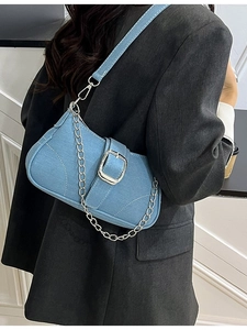Light blue denim shoulder bag with silver buckle and chain shown on a model