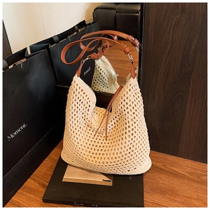 Detailed close-up of beige crochet woven bag featuring premium brown leather shoulder strap