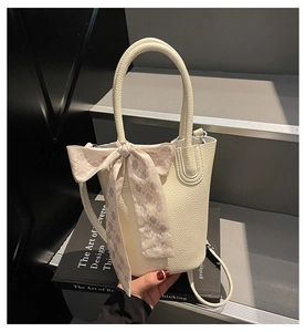White lychee leather bucket bag detail with purple checkered silk scarf on the handle