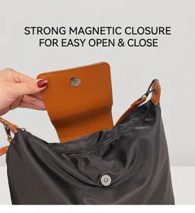Détail du sac fourre-tout en nylon noir montrant la boucle magnétique et la fermeture