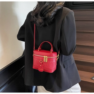 Detail of red PU leather bucket bag with woven texture and Fashion pendant on handle