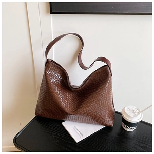 Close-up of dark brown woven leather texture on a high-capacity tote shoulder bag
